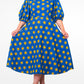 A model showcases a blue puff sleeve long dress adorned with playful yellow elements and paired with black classic heels.