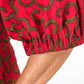 A close up of the puff sleeve of the red dress and its swirly details.