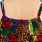 A close-up of the upper back portion of the dress, highlighting the details such as the straps, waistline, and colourful patchwork elements. 