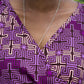 Close up of purple ruffle print dress neck line, paired with a silver long necklace.