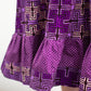 A close-up view accentuating the ruffle effect of the dress, particularly showcasing the point where the fabric print transitions into a purple line with white polka dots.