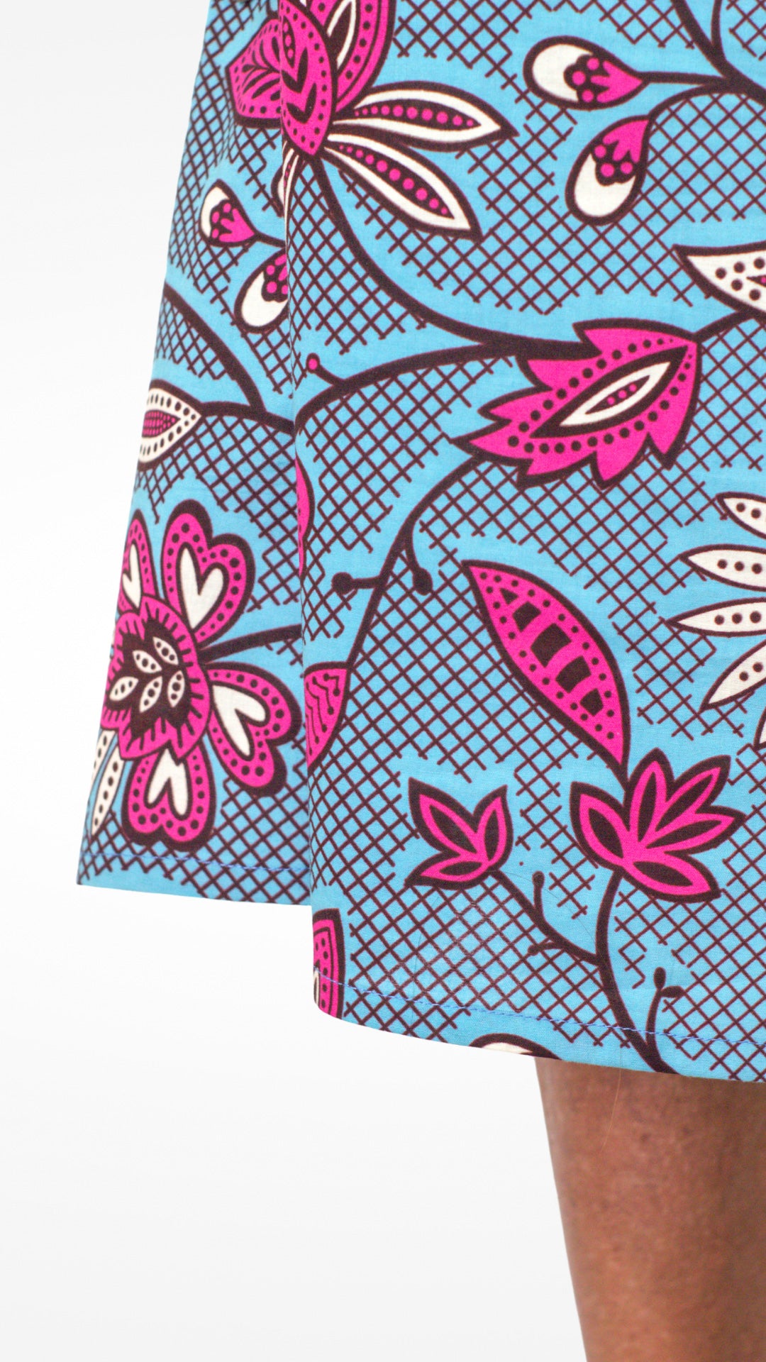 A close-up view focusing on the neckline of the blue print kaftan-style dress with pink elements, highlighting the fit and the high quality of the fabric.