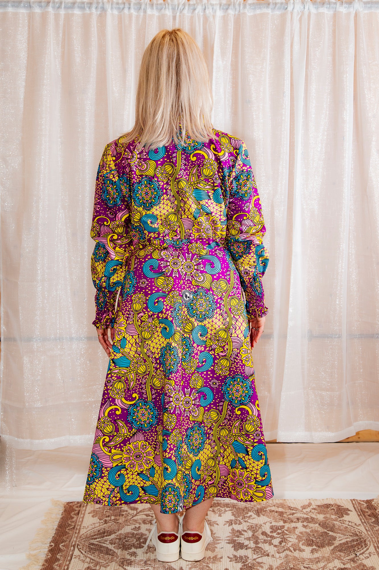 model showing the back of Model posing in Onyeka African Print Shirt Dress in Purple