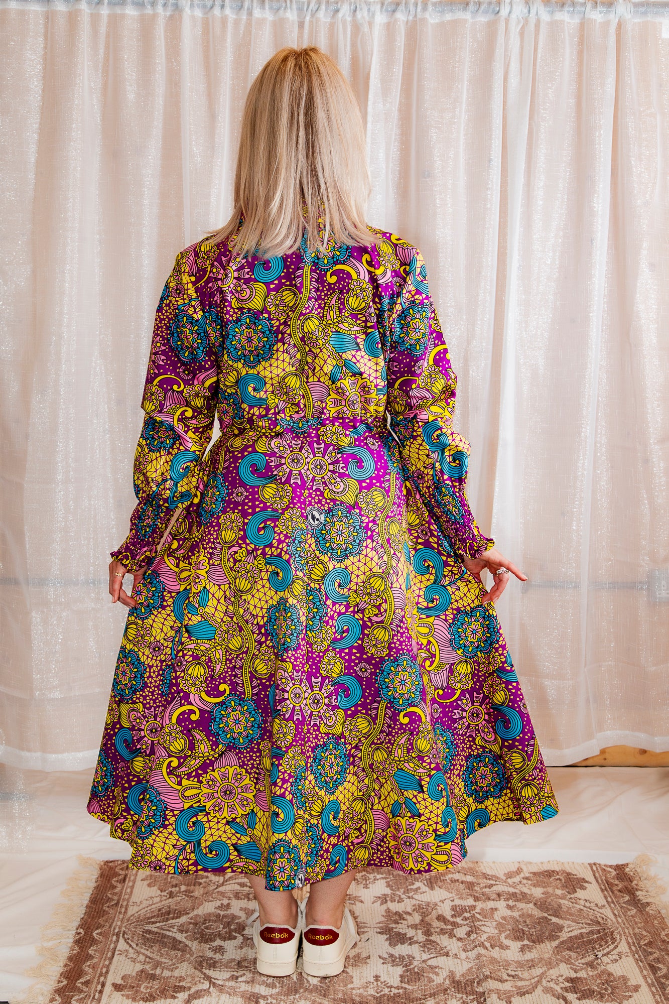 model showing the back of Model posing in Onyeka African Print Shirt Dress in Purple