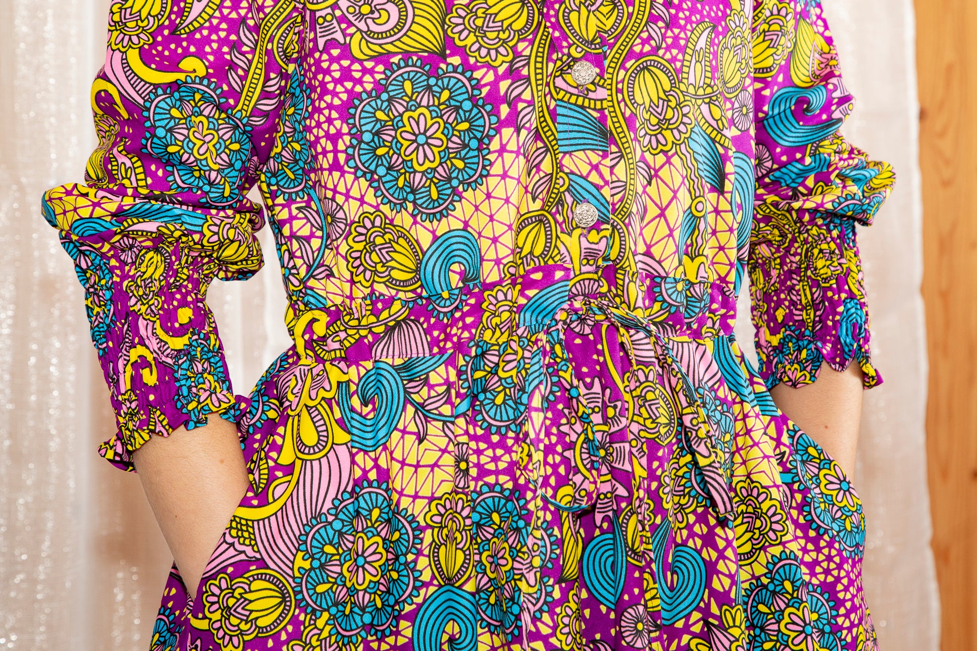 close up of model showing the back of Model posing in Onyeka African Print Shirt Dress in Purple
