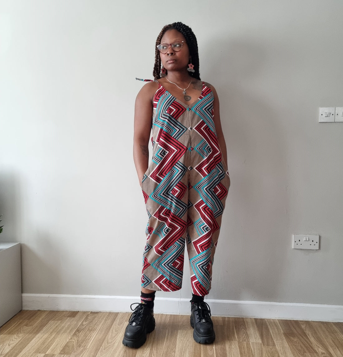 Montana exuding style and confidence in a striking 'Mimi G Style' jumpsuit made from the 'Fashionably Late' African print wax fabric by Dovetailed London, embracing bold patterns and contemporary fashion.