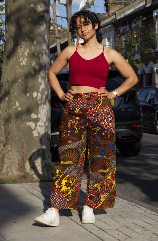 Image of Jay, wearing self-drafted African wax print trousers from Dovetailed London with vibrant patterns, showcasing her unique style.