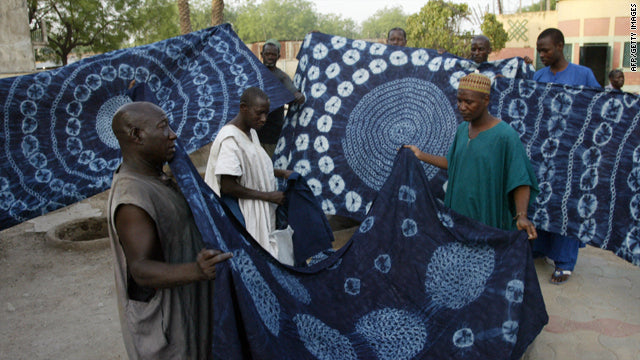 Men fixing and hanging Adire cloths, indigo dyed fabric.