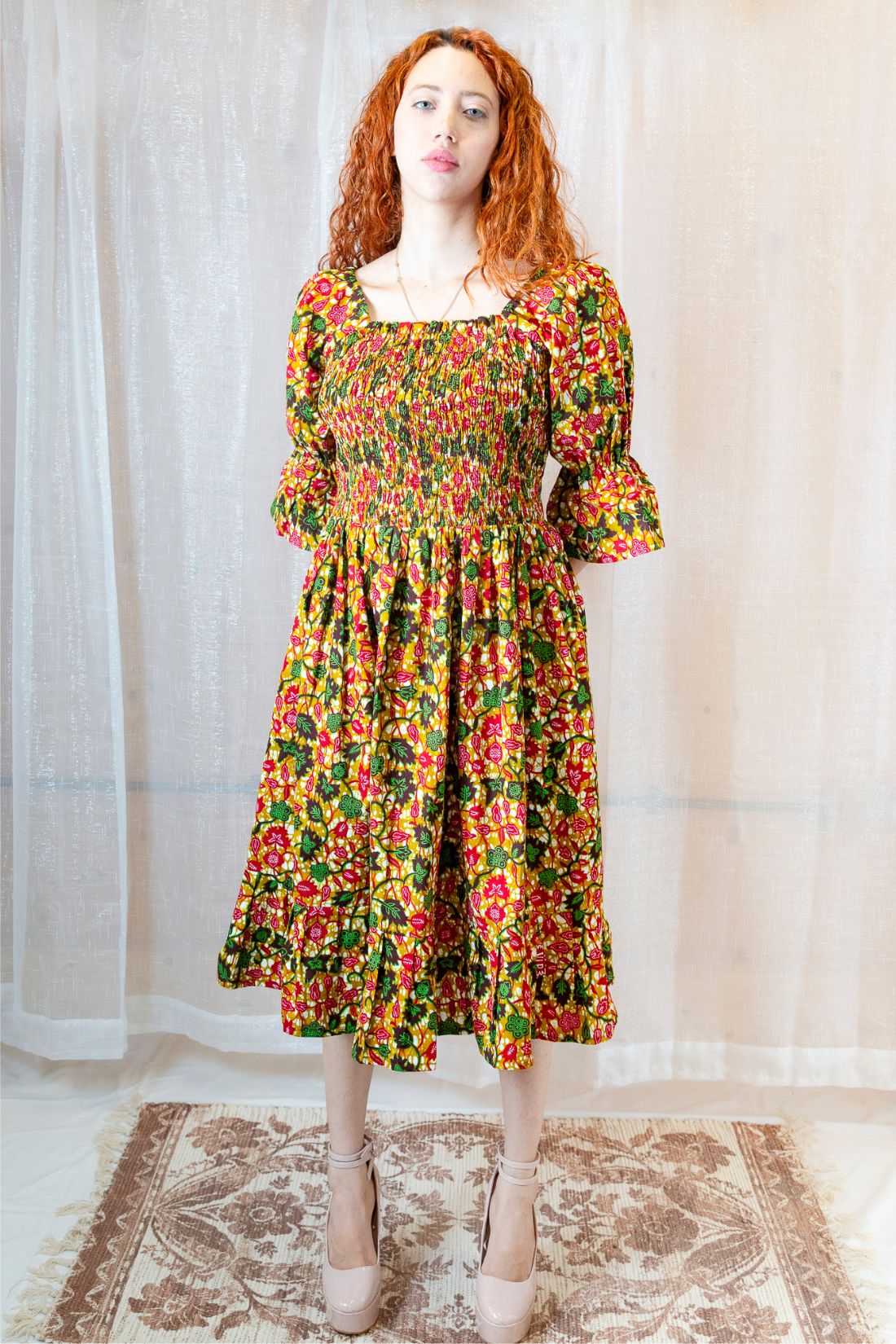 Woman wearing a yellow, green and pink midi floral dress