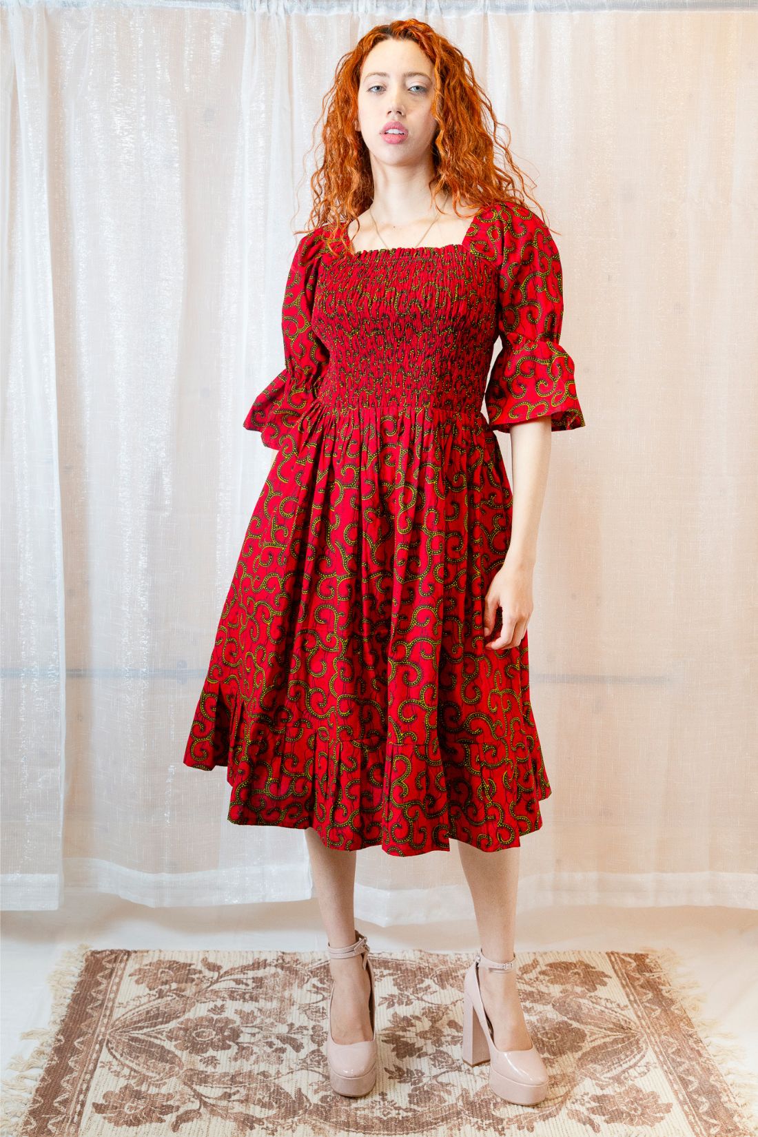 A person with red hair wearing a red dress