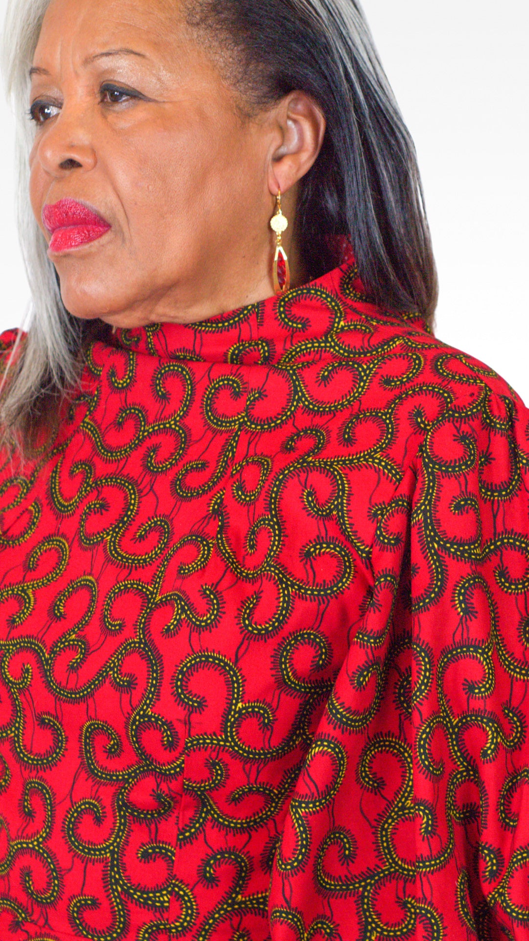 A close-up view highlighting the the red dress and its swirly elements.