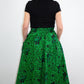 the back of the model wearing a botanical green print skirt reveals a beautiful silhouette. 