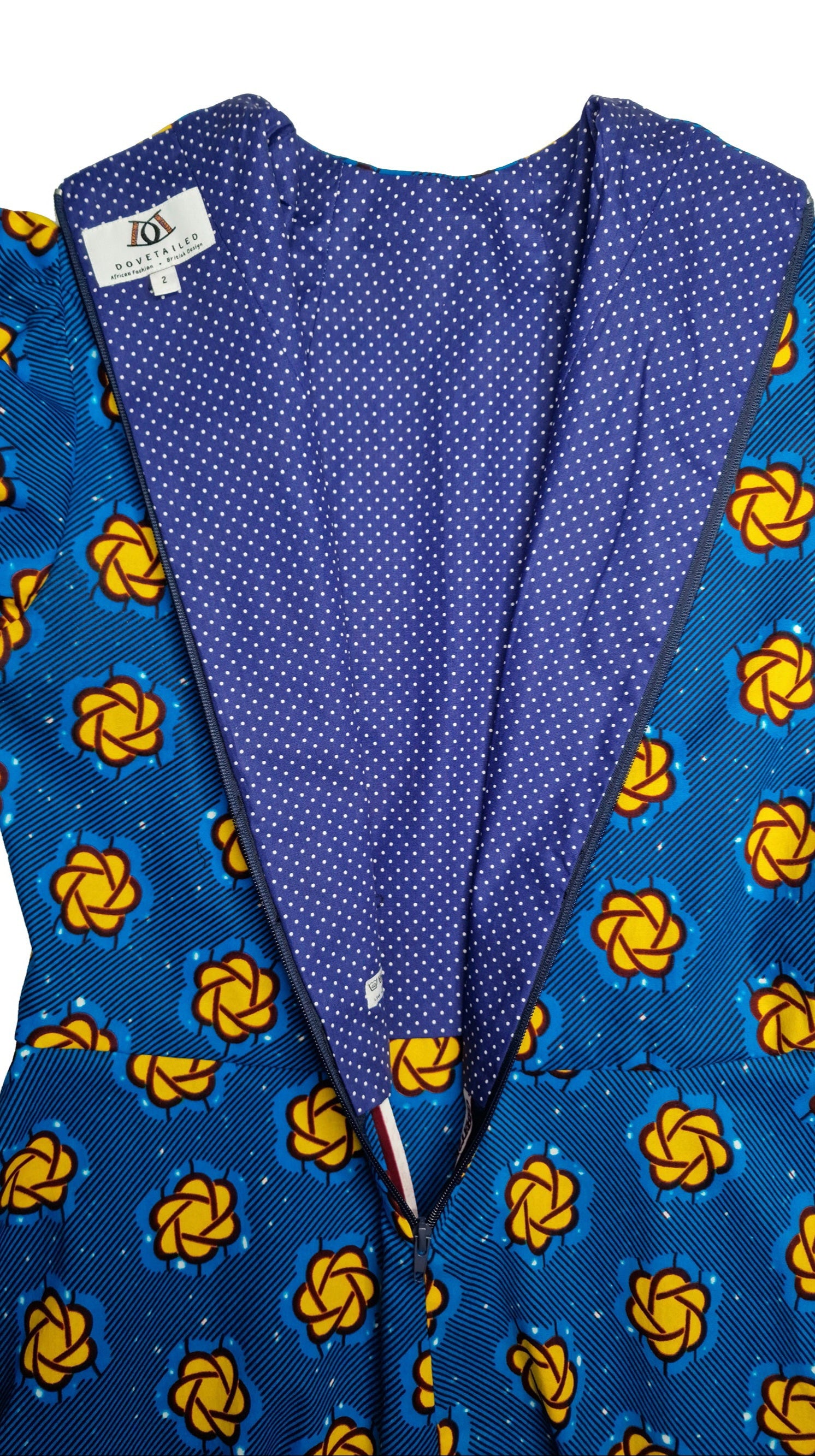 A close-up view of the rear zipper of the blue print dress reveals a darker shade of blue inside fabric, emphasising the high quality of the garment.