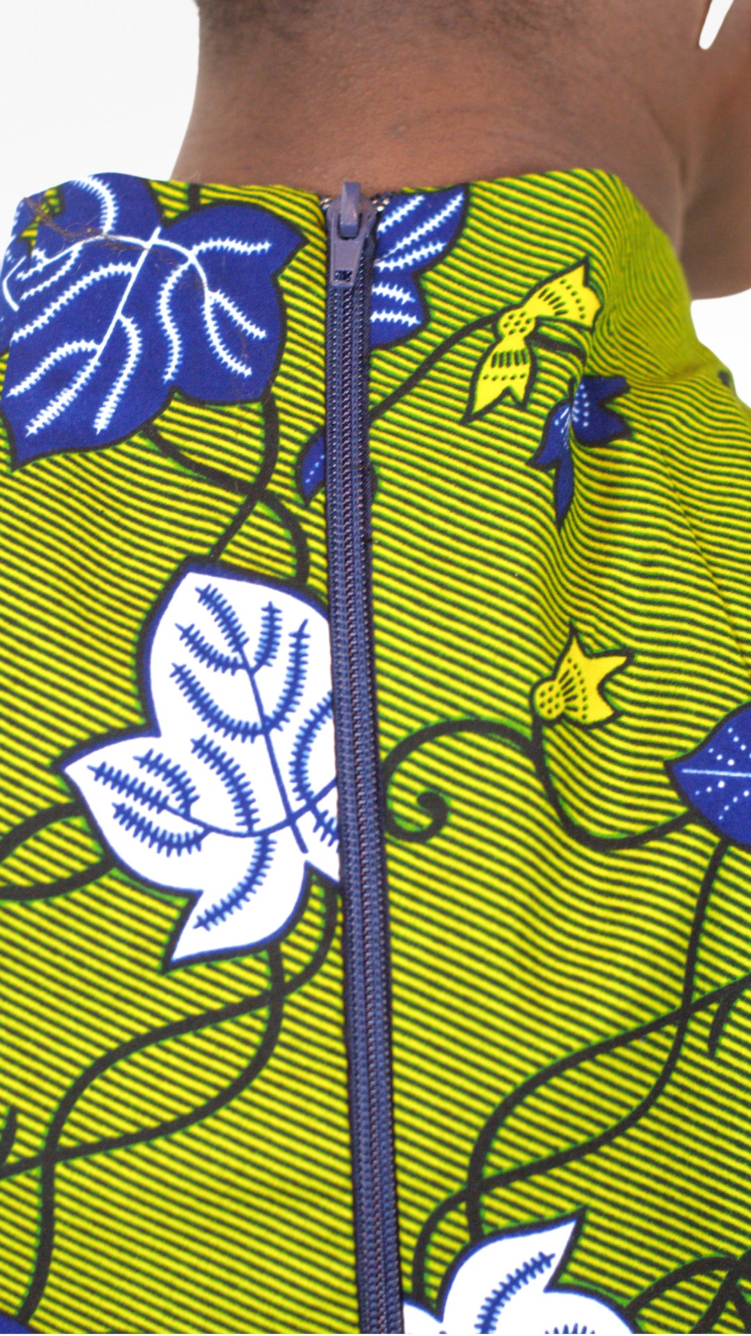 A close up rear view of the blue zipper of the khaki dress, added for functionality.