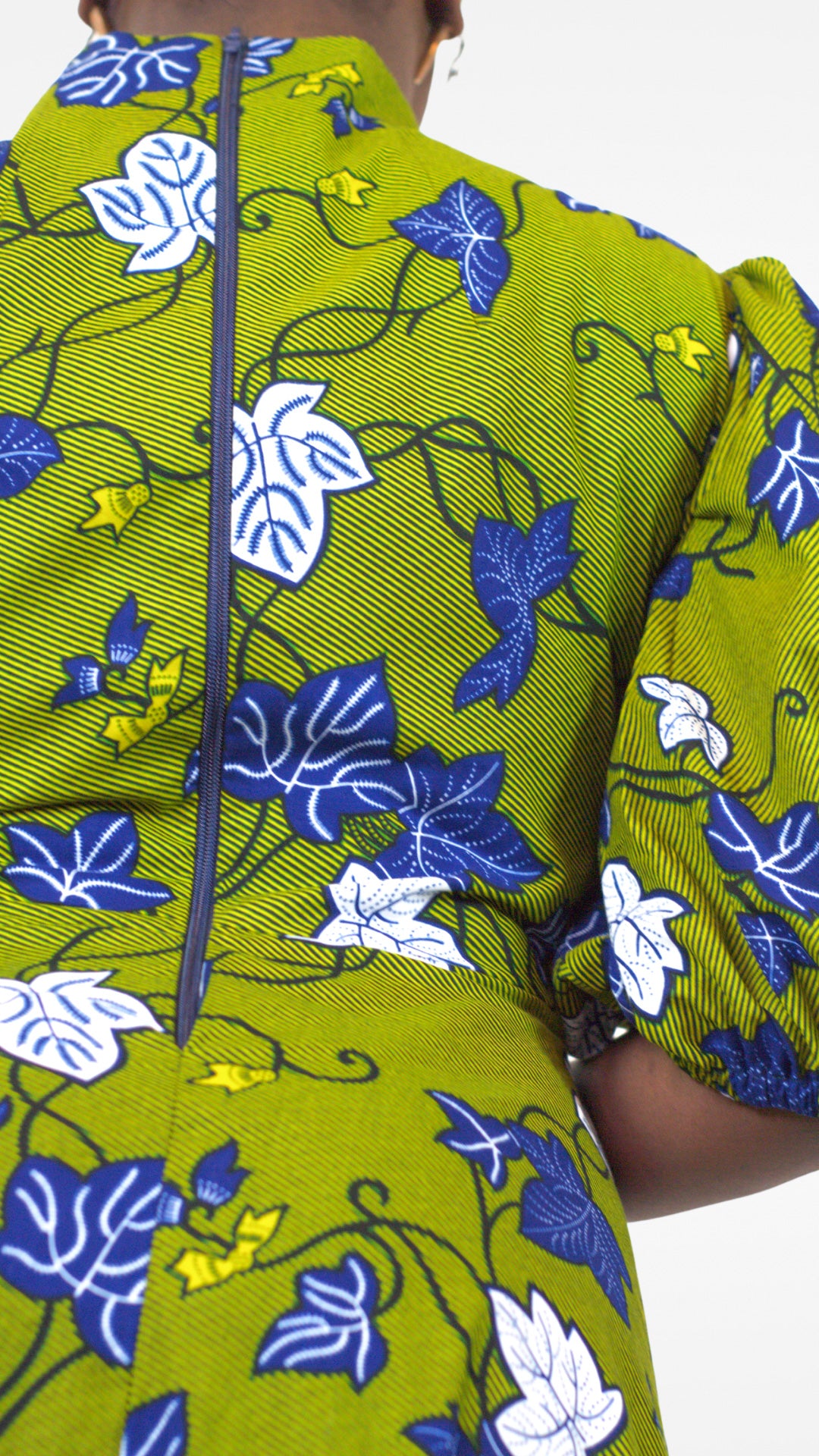 A close up rear view of the khaki dress, showcasing the zipper closure at the back and the enchanting blue and white pattern.