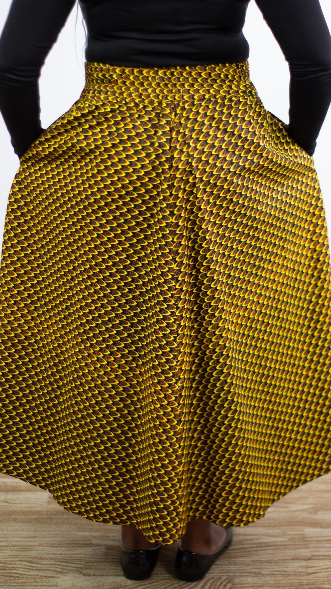 A close-up view capturing the back of a yellow African print skirt, showcasing a harmonious blend of vibrant African print patterns.