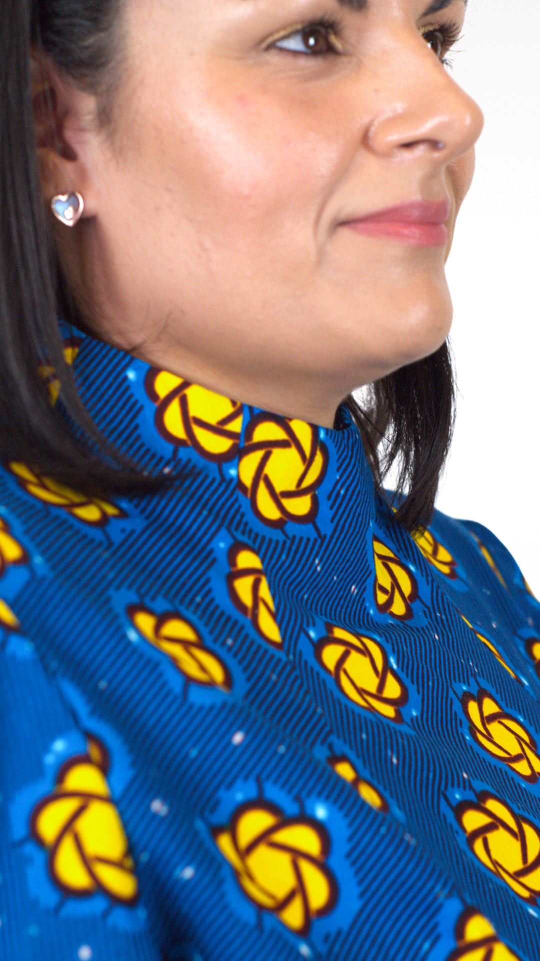 A side close-up view captures the details of the neckline of the blue dress, adorned with yellow elements.