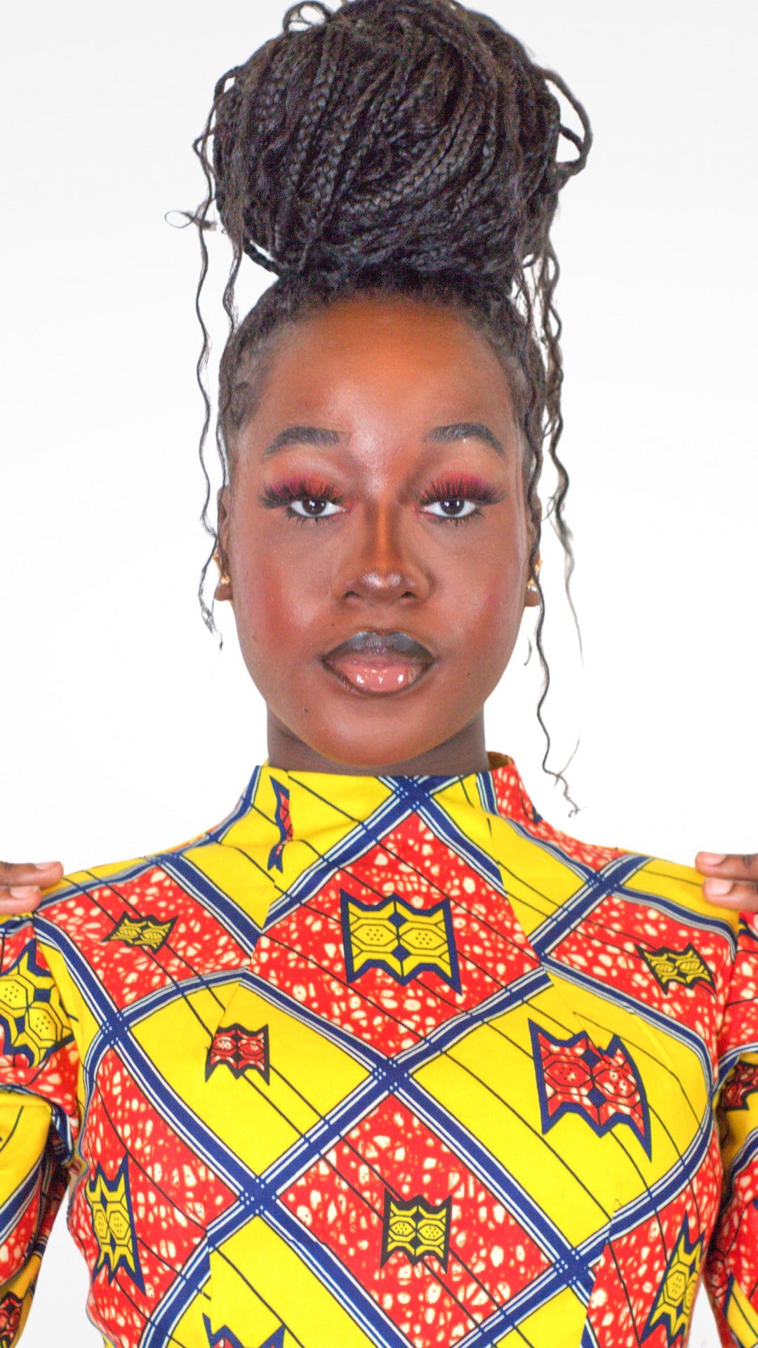 A model wearing red eyeshadow paired with the yellow red print dress.