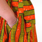 a close up of a person's hand in a yellow orange striped skirt and showcasing the deep pockets and comfortability