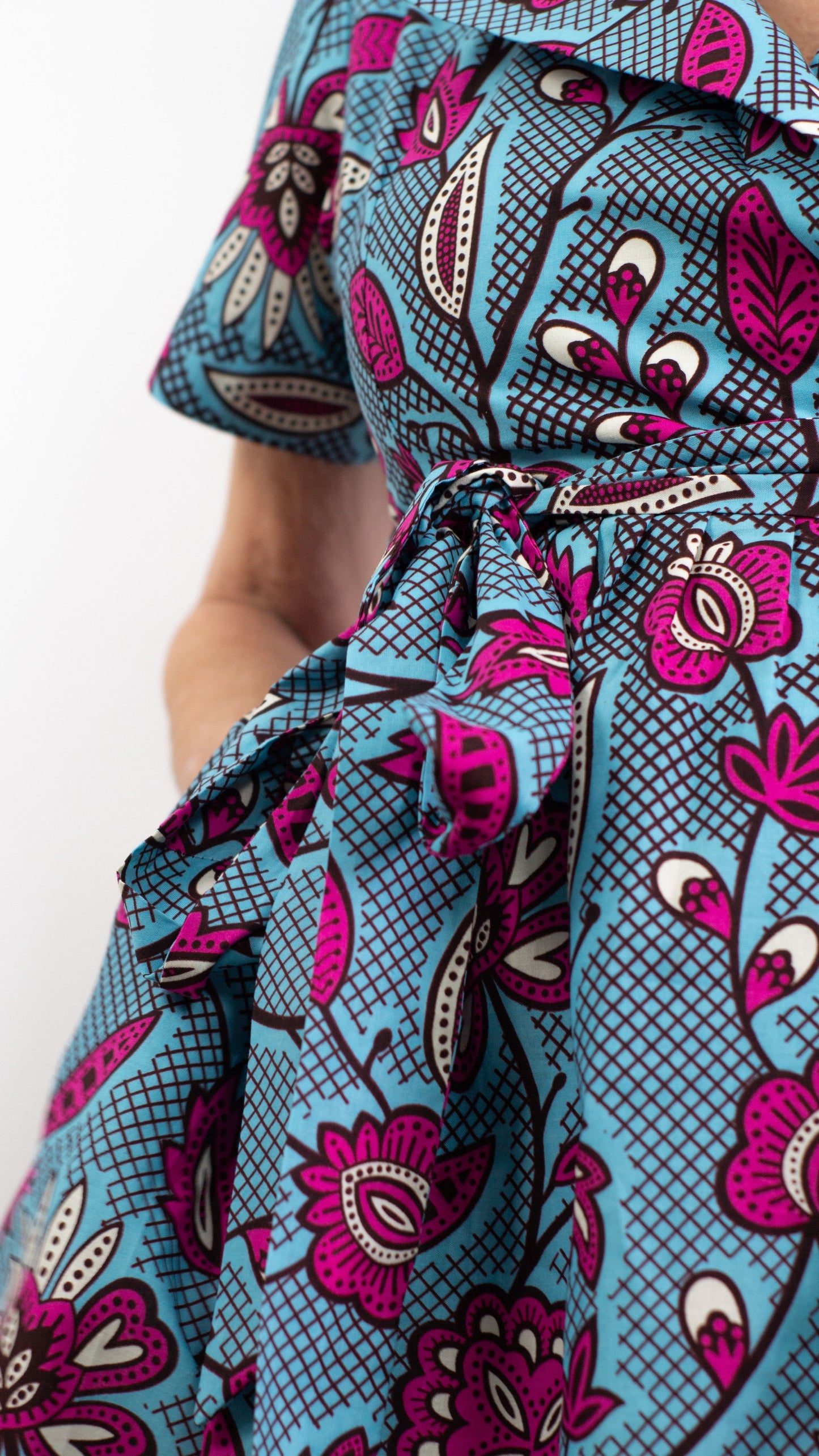 A detailed view of the print tie belt adorned on the dress, accompanied by a deep pocket. 