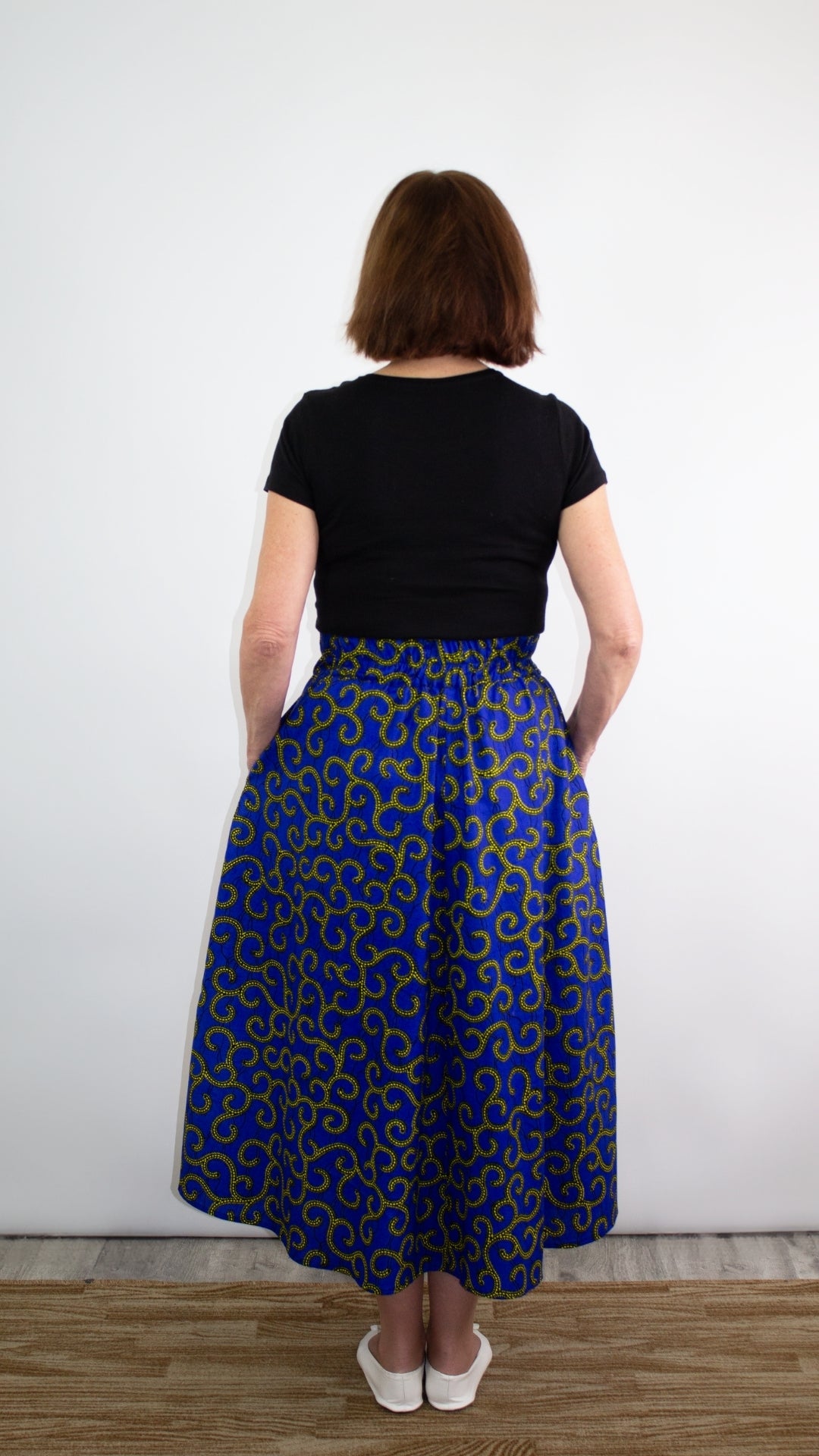 Back of the swirly blue print skirt with golden elements, accentuating a beautiful, flowing silhouette.