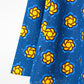 A close-up, highlighting the blue fabric and yellow design details of the bottom of the dress gracefully.