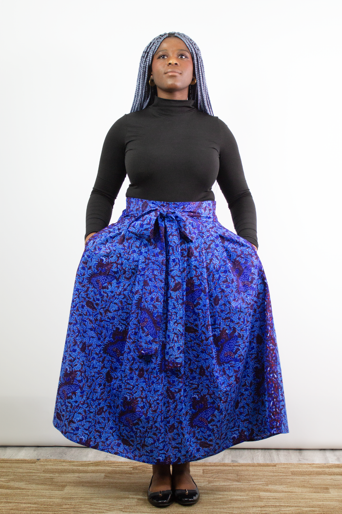 A model posing in Phoebe Blue Botanical Pleated Maxi Skirt