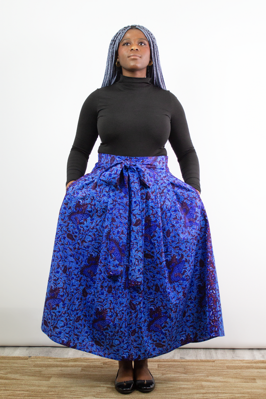 A model posing in Phoebe Blue Botanical Pleated Maxi Skirt