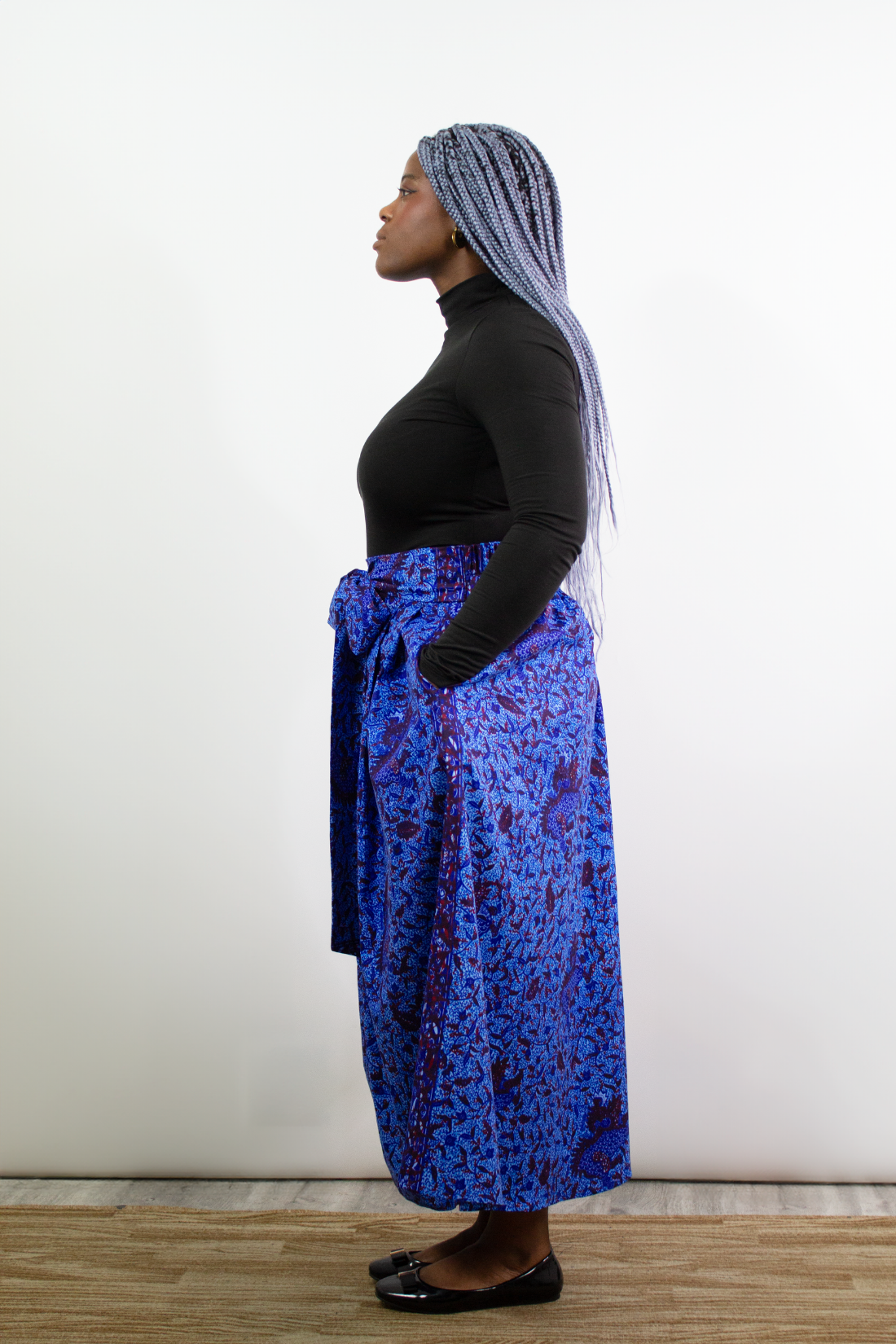 A model posing in Phoebe Blue Botanical Pleated Maxi Skirt.