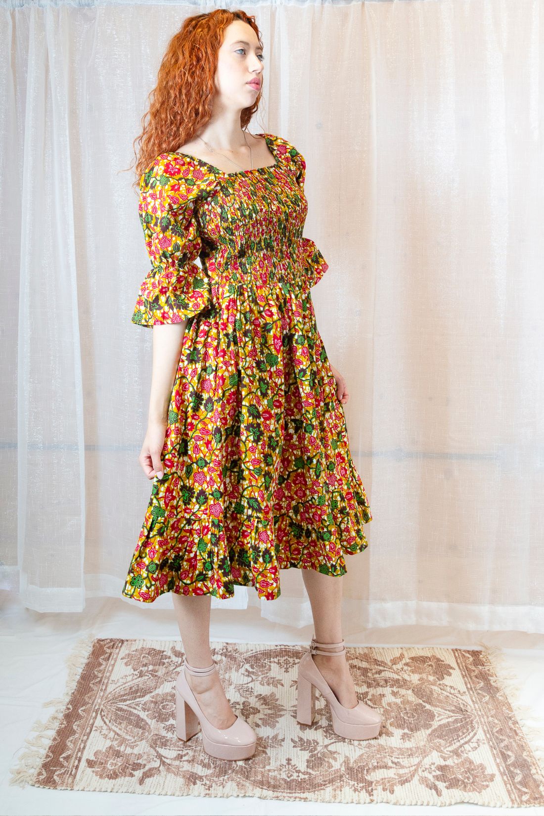 Woman wearing a yellow, green and pink midi floral dress