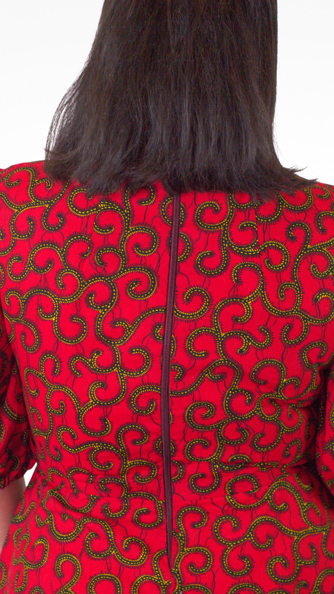 A rear view of the red dress, showcasing the zipper closure at the back.