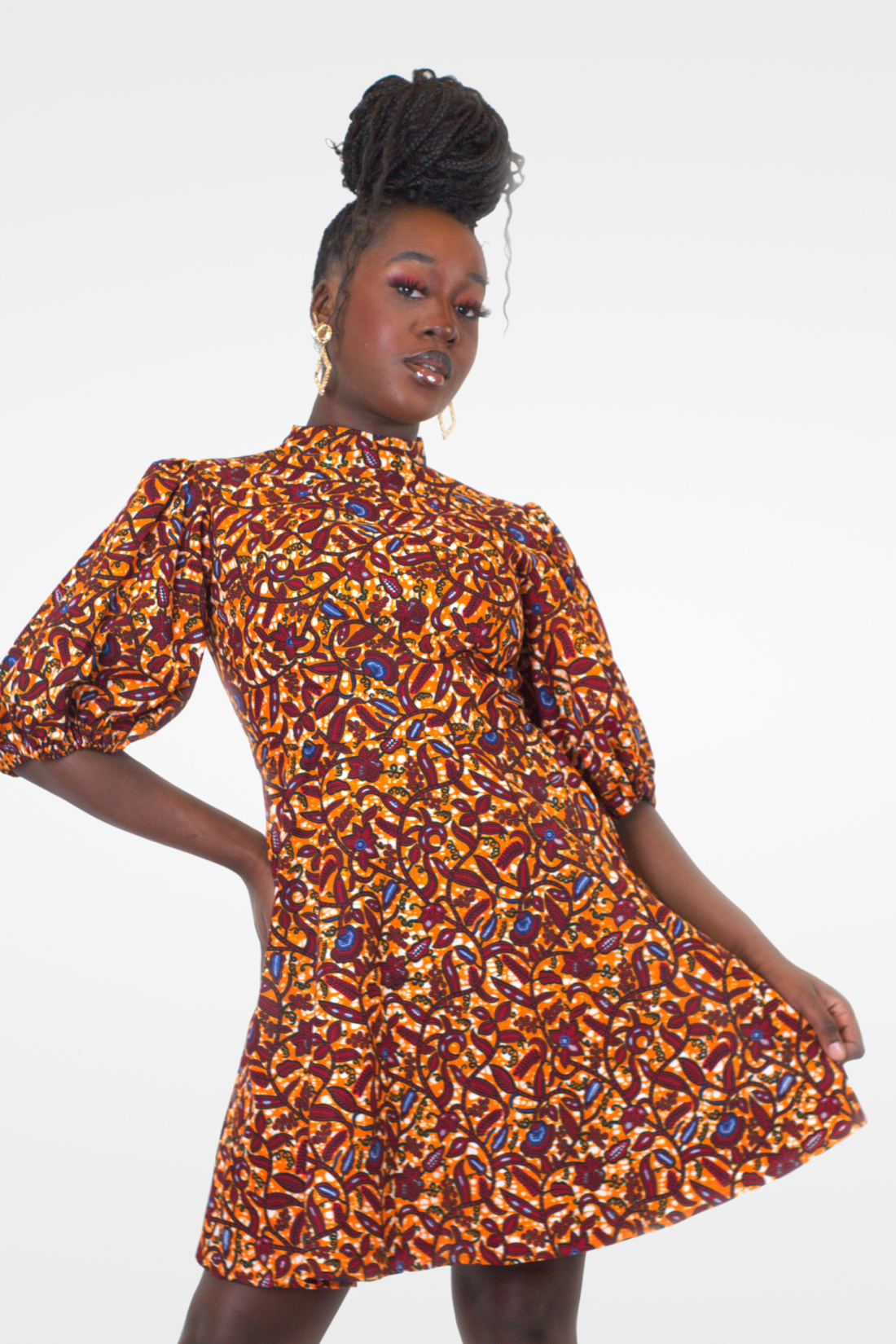 Model posing in Camille African Print Puff Sleeve Knee-Length Dress Orange Ankara.