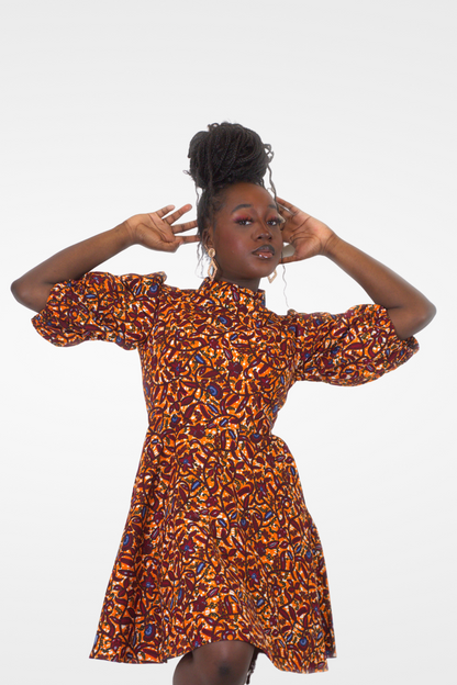 Model posing in Camille African Print Puff Sleeve Knee-Length Dress Orange Ankara.