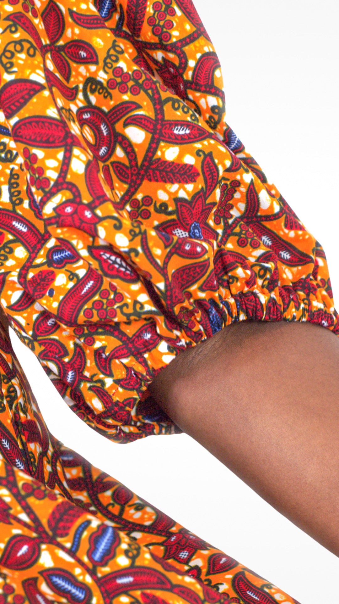 A close-up view highlighting the charming puff sleeve and detailed floral elements of the orange dress.