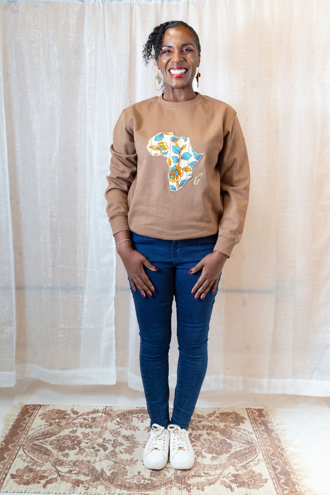 A person wearing a brown sweatshirt with a map of Africa on it