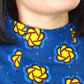 A close-up view captures the details of the neckline of the blue dress, adorned with yellow elements.