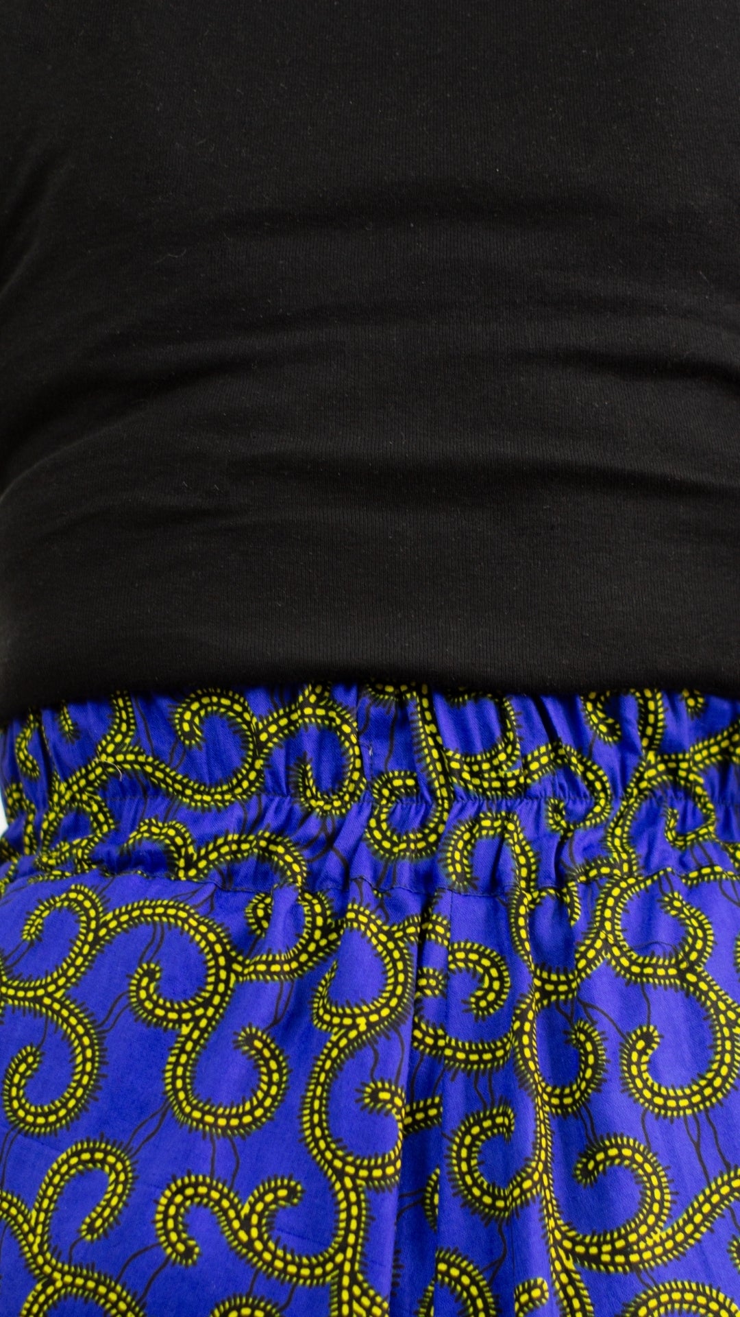 Close up of the elasticised waistline of a beautiful swirly blue skirt with golden elements.