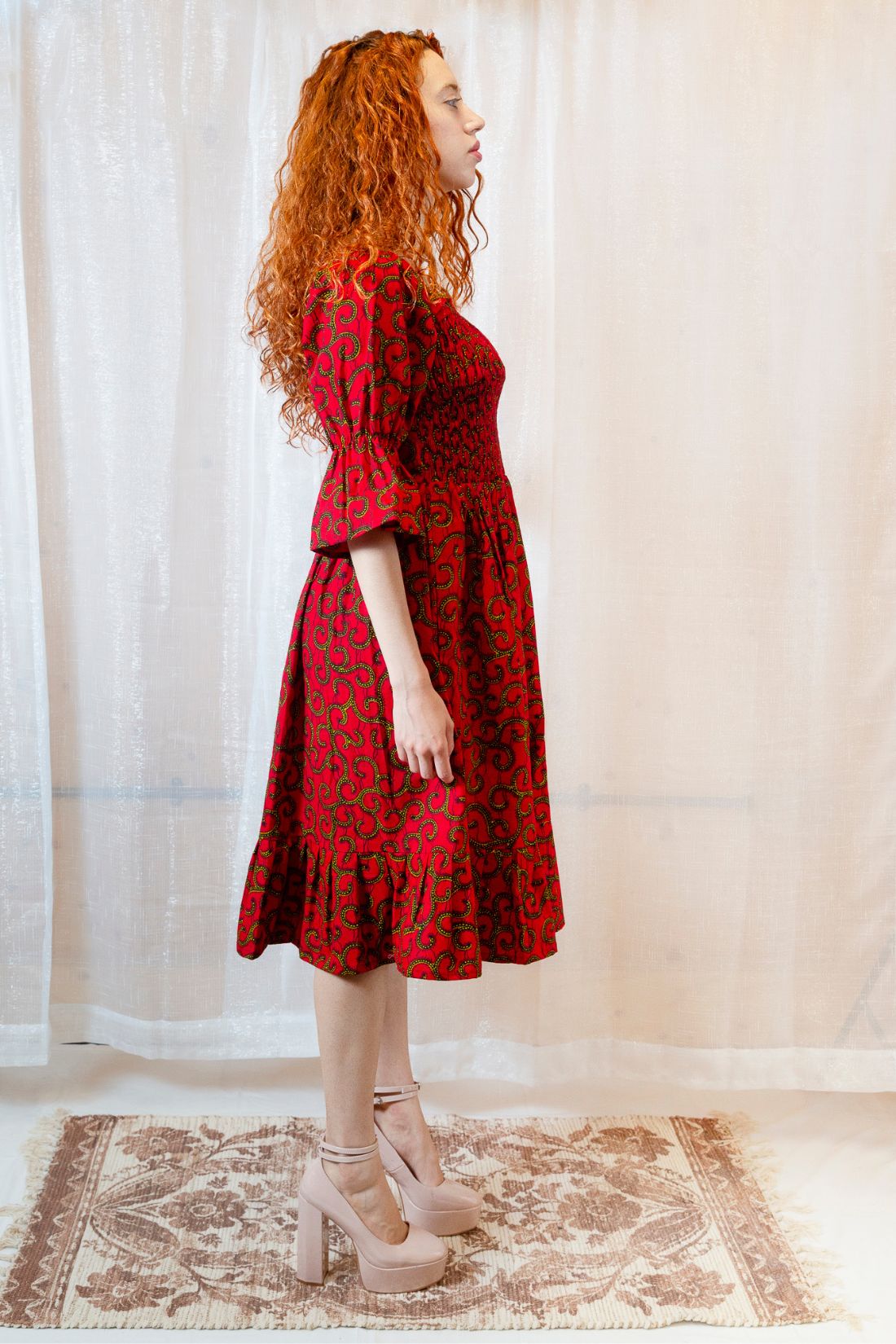 A person with red hair wearing a red dress