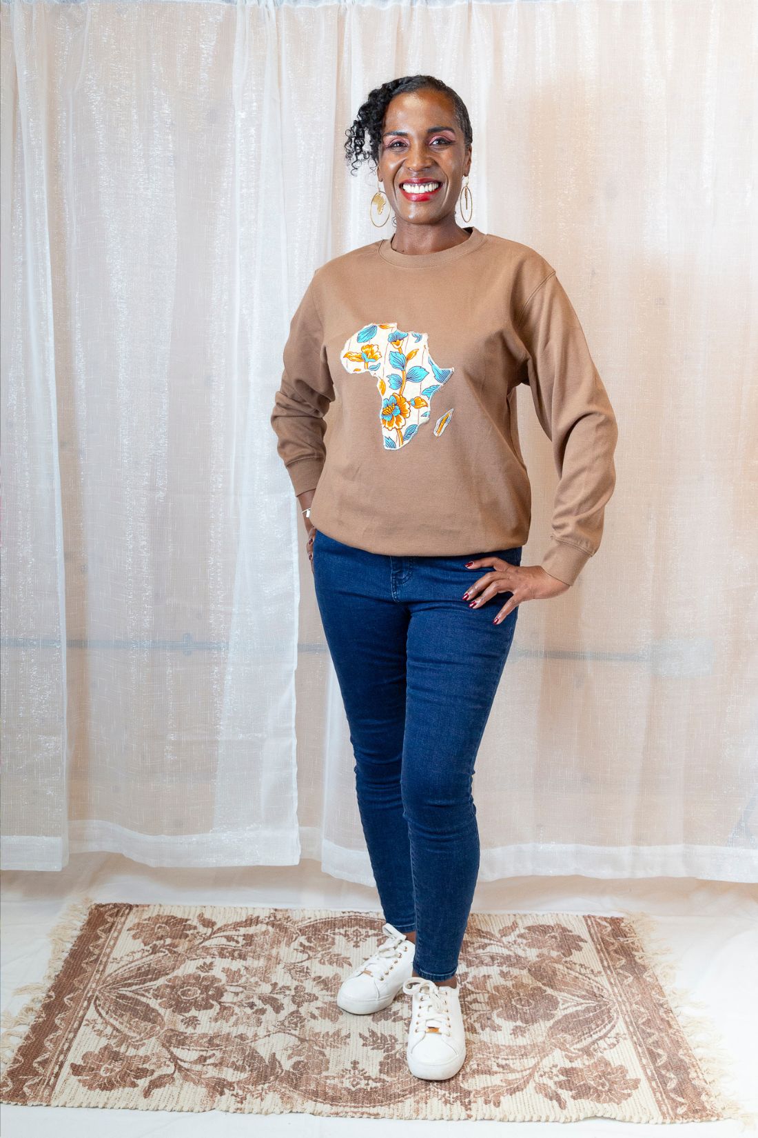 A person wearing a brown sweatshirt with a map of Africa on it