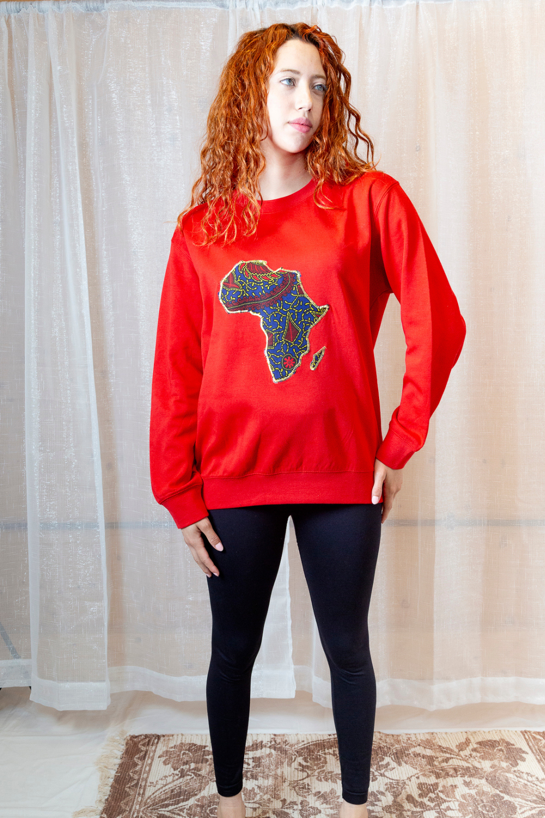 A person wearing a red sweatshirt with an Africa map on it