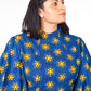 A close up of the top part of the blue puff sleeve dress, highlighting the vibrant yellow elements of the print.