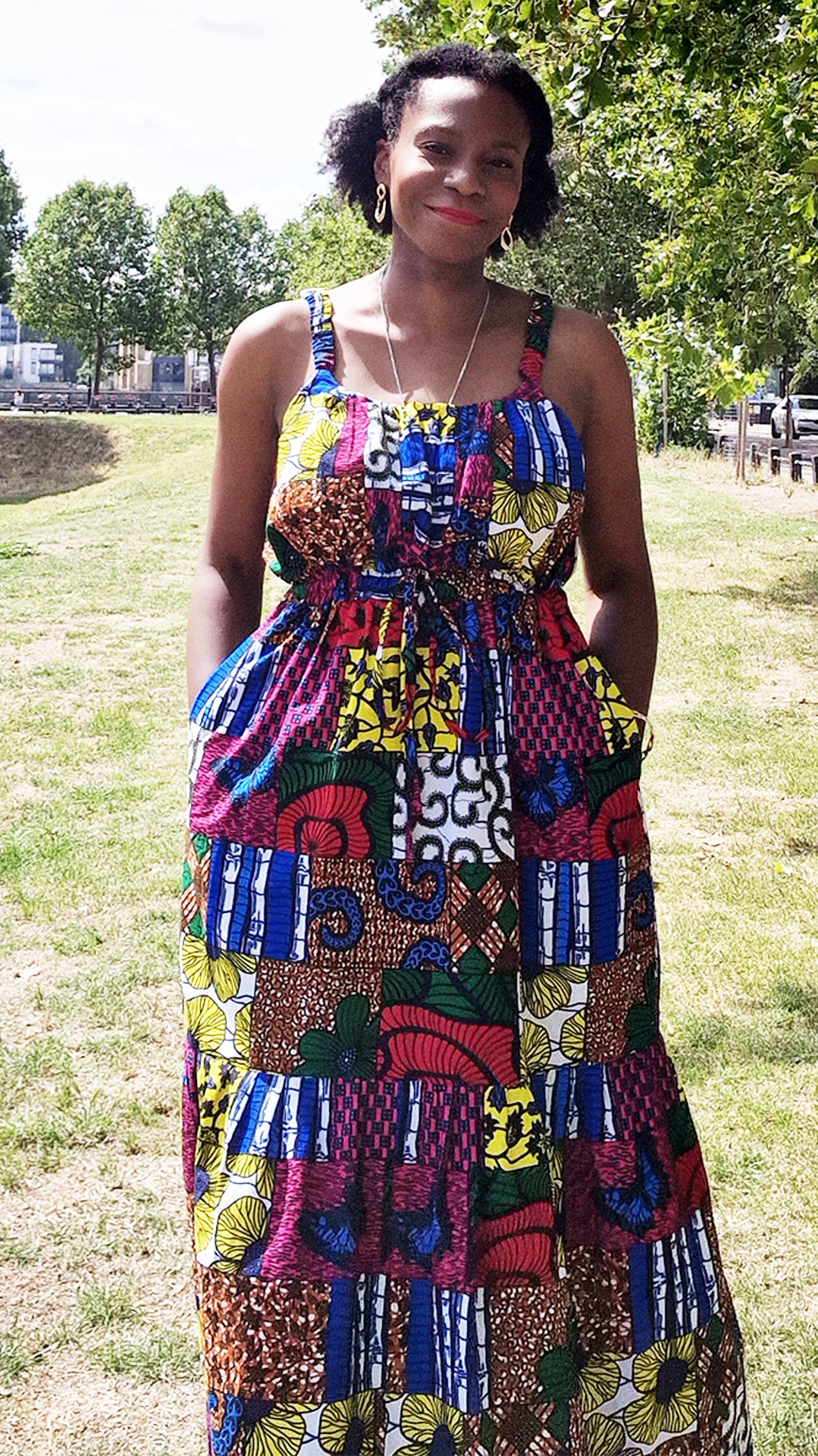 In the midst of a park setting, a woman radiates elegance in a Beatrice maxi print dress. 