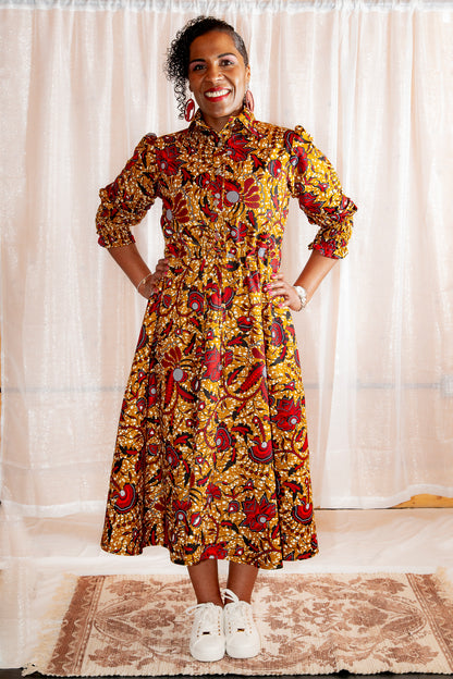 model posing and smiling in Onyeka African Print Shirt Dress in Brown Ankara Dress paired with white trainers