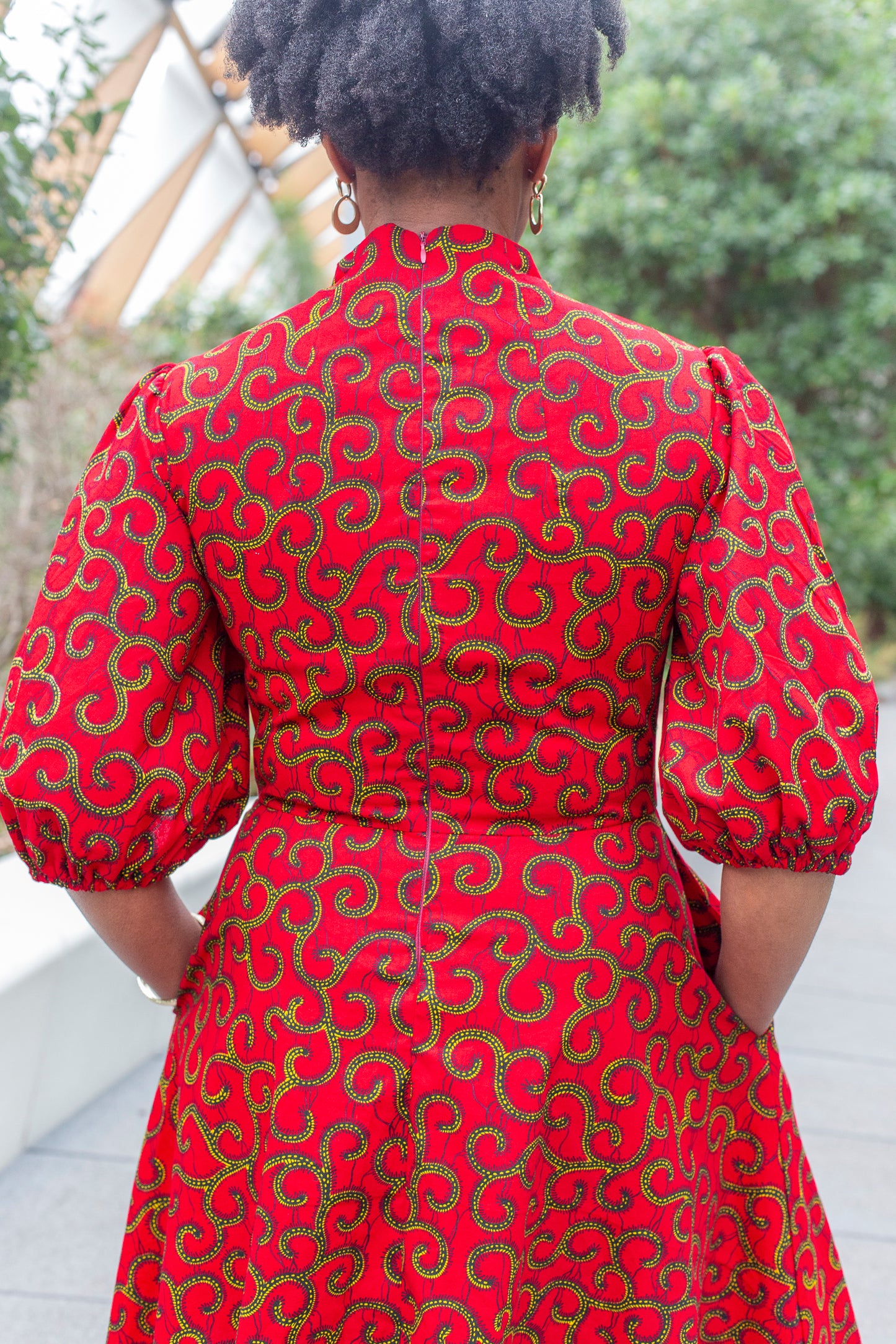 A rear view of the red dress, showcasing the zipper closure at the back for added functionality.
