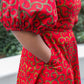 A close-up view highlighting the charming puff sleeve and a practical pocket of the red short dress.