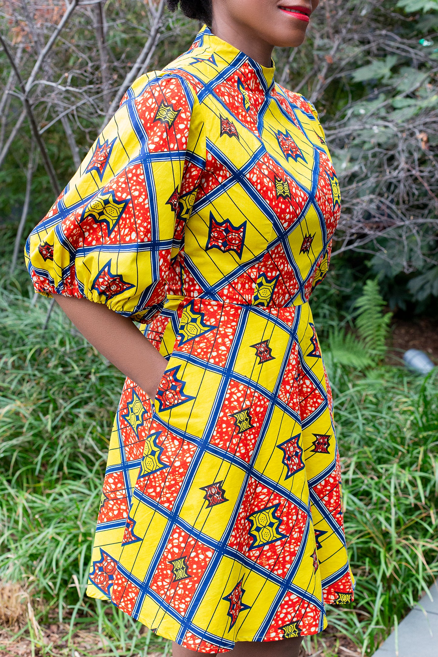 A side view of the pockets and elements of the yellow puff sleeve short dress.