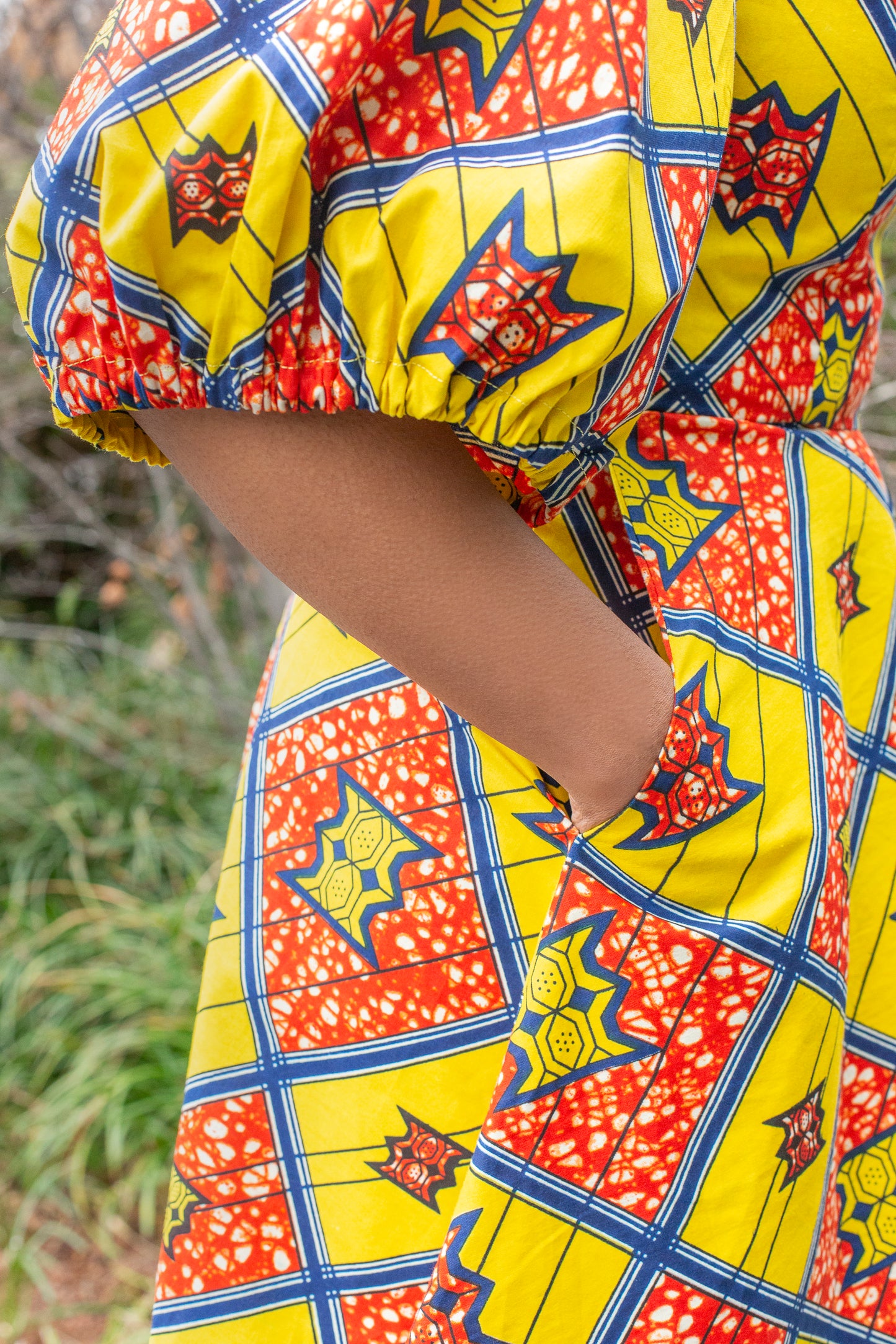 A close-up view highlighting the charming puff sleeve and a practical pocket of the dress.